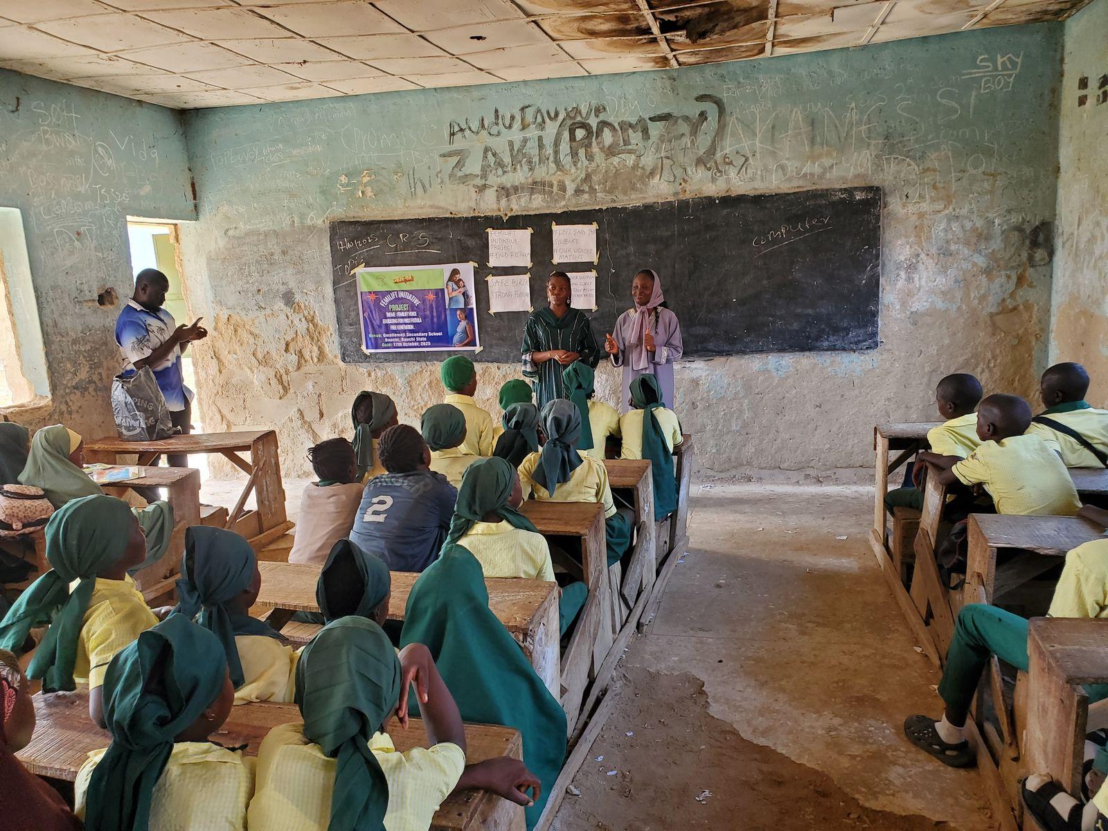 Two FCI volunteers talk about fistula with a full classroom of schoolgirls